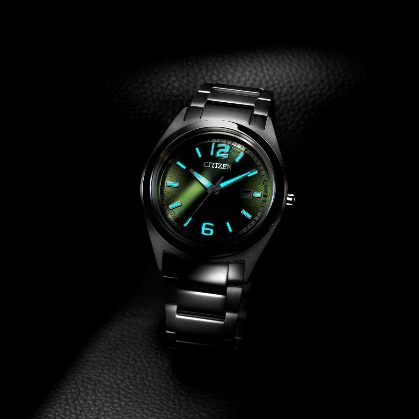 Citizen-Uhr mit leuchtenden Zeigern und Ziffern auf dunklem Hintergrund.