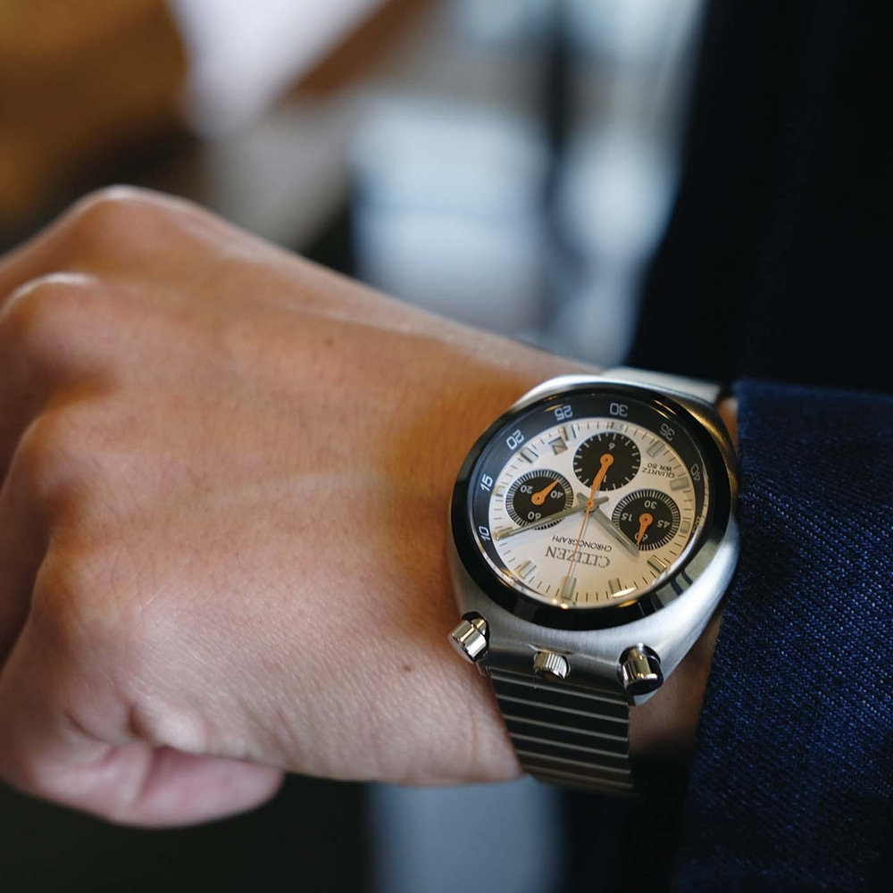 Das Handgelenk eines Mannes mit einer silbernen Citizen-Chronographenuhr.