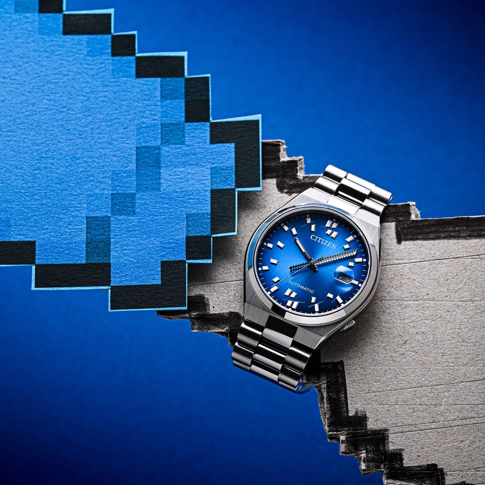 Eine blaue Citizen Automatik-Uhr auf pixeligem Hintergrund.