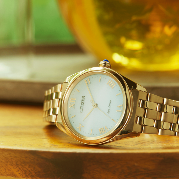 Goldene Citizen-Uhr auf Holzoberfläche, Nahaufnahme, elegantes Design, luxuriös.