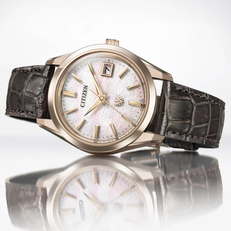 Citizen-Uhr mit weißem Zifferblatt und braunem Lederarmband, elegantes Design.