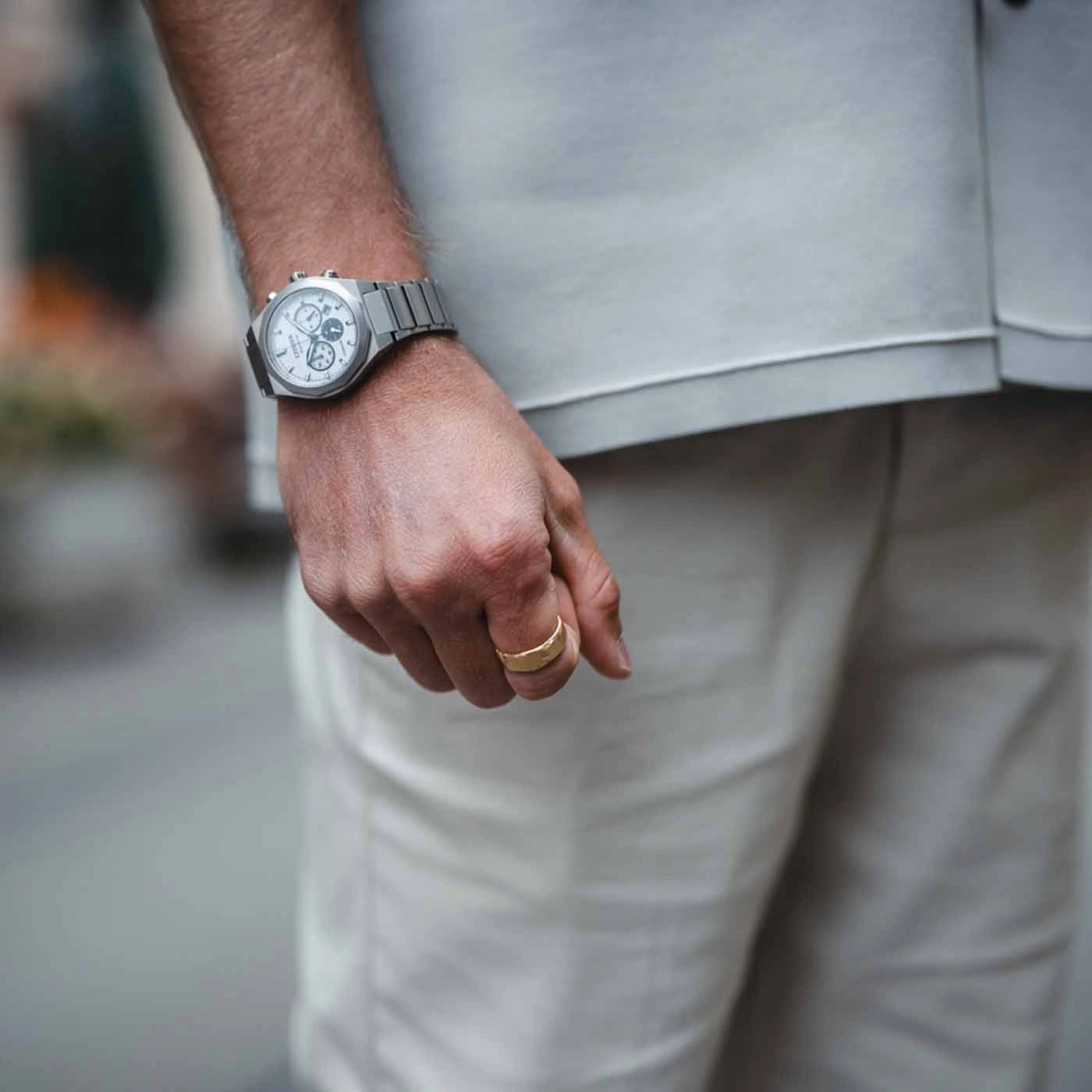 Mann trägt Uhr und Goldring, Nahaufnahme seiner Hand und Kleidung.