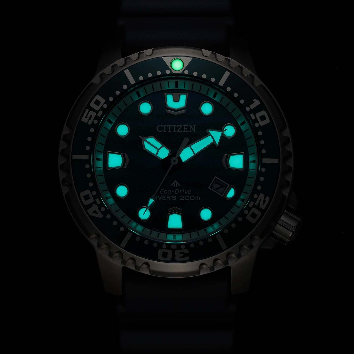 Eine leuchtend grüne Citizen Eco-Drive Taucheruhr leuchtet im Dunkeln.